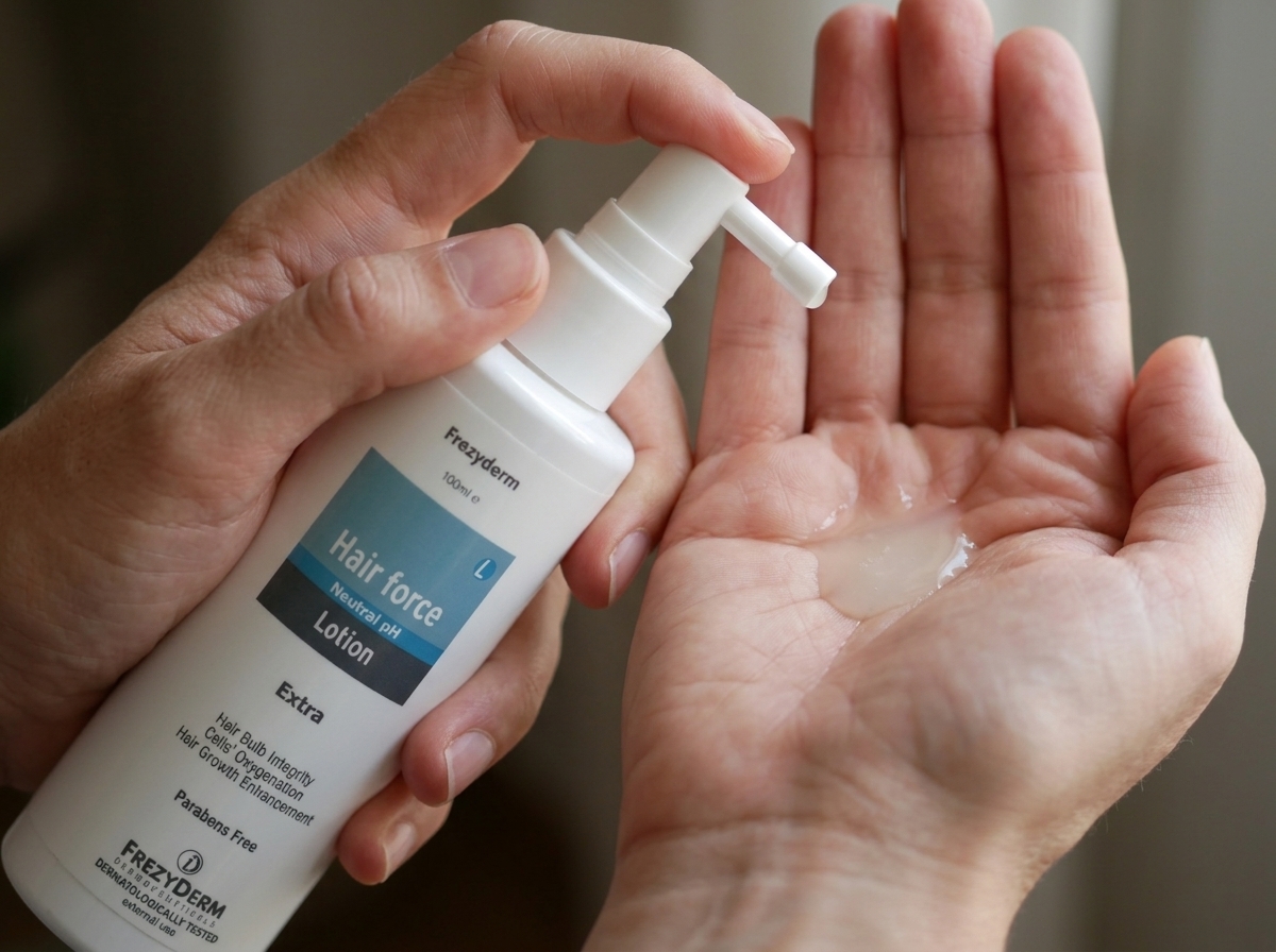 Mano con una pequeña cantidad de HAIR FORCE LOTION Frezyderm
